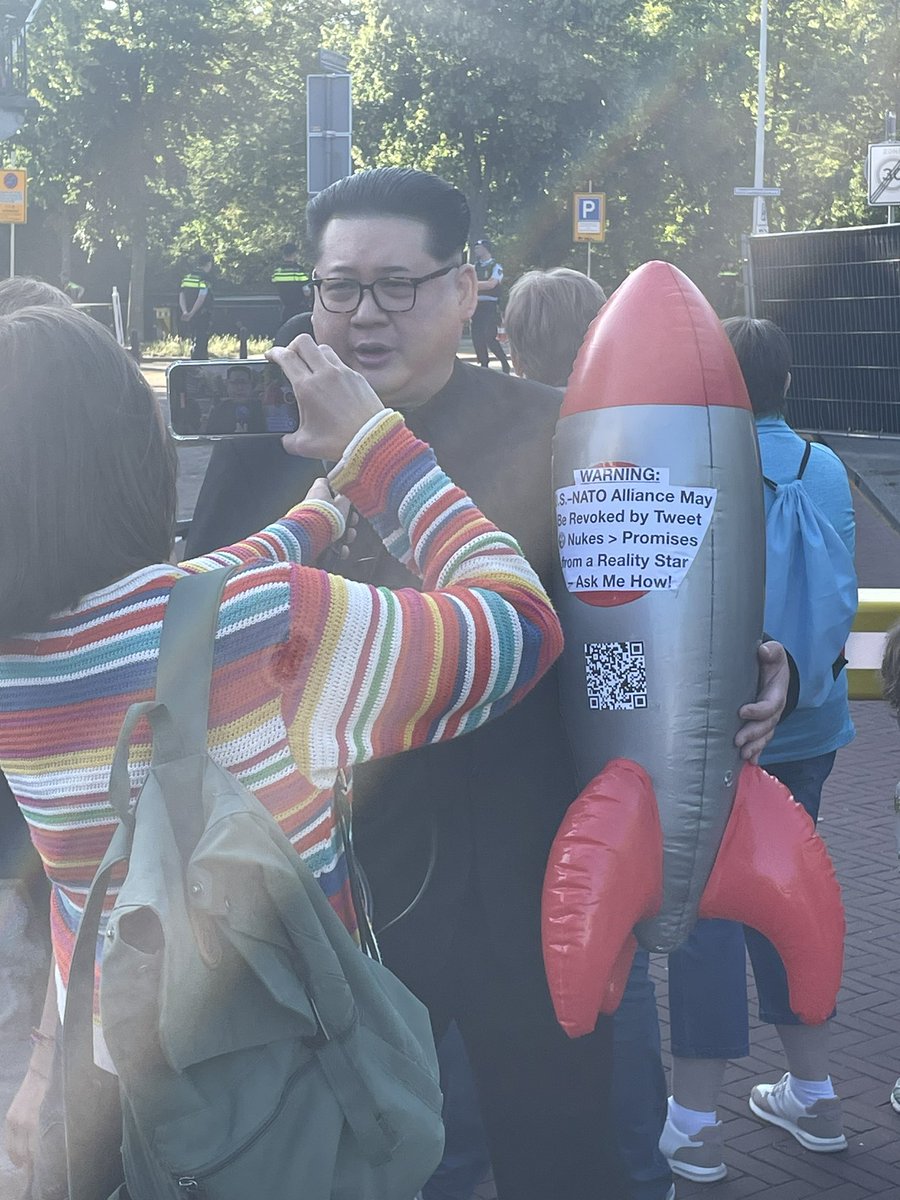 Een man verkleed als Kim Jong-un loopt roepend op de blokkade bij het paleis af. Hij noemt zich de ‘supreme leader’ en een goede vriend van Trump. In zijn handen draagt hij een opgeblazen raket. Zegt dat ‘Trump en andere dictators’ niet te vertrouwen zijn.