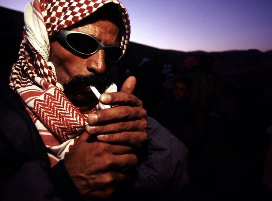 ShaykhSulaiman's tweet photo. Palestinian man lights a cigarette, Palestine, 2000. https://t.co/Gxuka0UkYY