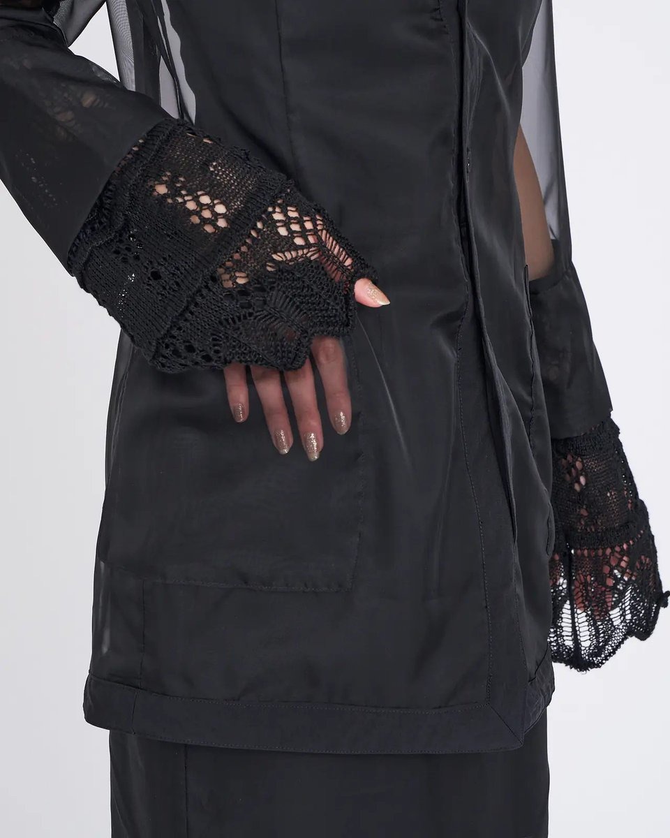 センシュアルな透け感に惹かれる「オダカ」のシアージャケットは、カーディガン感覚で軽く羽織ることができるレイヤードアイテム。甘い印象に寄りすぎない奥深いブラックと、エレガントな佇まいを忘れないブランドらしいレース地の袖口で、バランス感の良い凛とした表情に仕上げています。