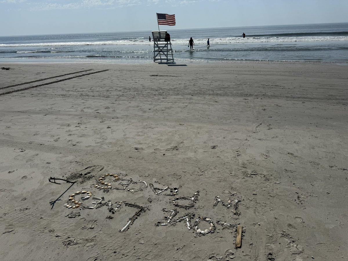 Spelled, “Love Lives in Peaces” with shells today. When I was done, saw a lot in the shadows &amp; the flag in the background.

A symbol of peace from pieces? 

What do you think?