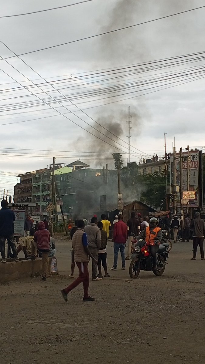 TheKaslim's tweet photo. UPDATES;Quickmart Rongai Building stoned. Goons burn down the 24 hours police post next to it. Tyres burning and they have breached the butchery behind. These are not protestors. These are intentional looters keen on stealing from these businesses. https://t.co/9mLPlnBQp5