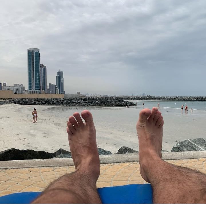 Sandy toes and suitcases" A mix of relaxation and business travel.