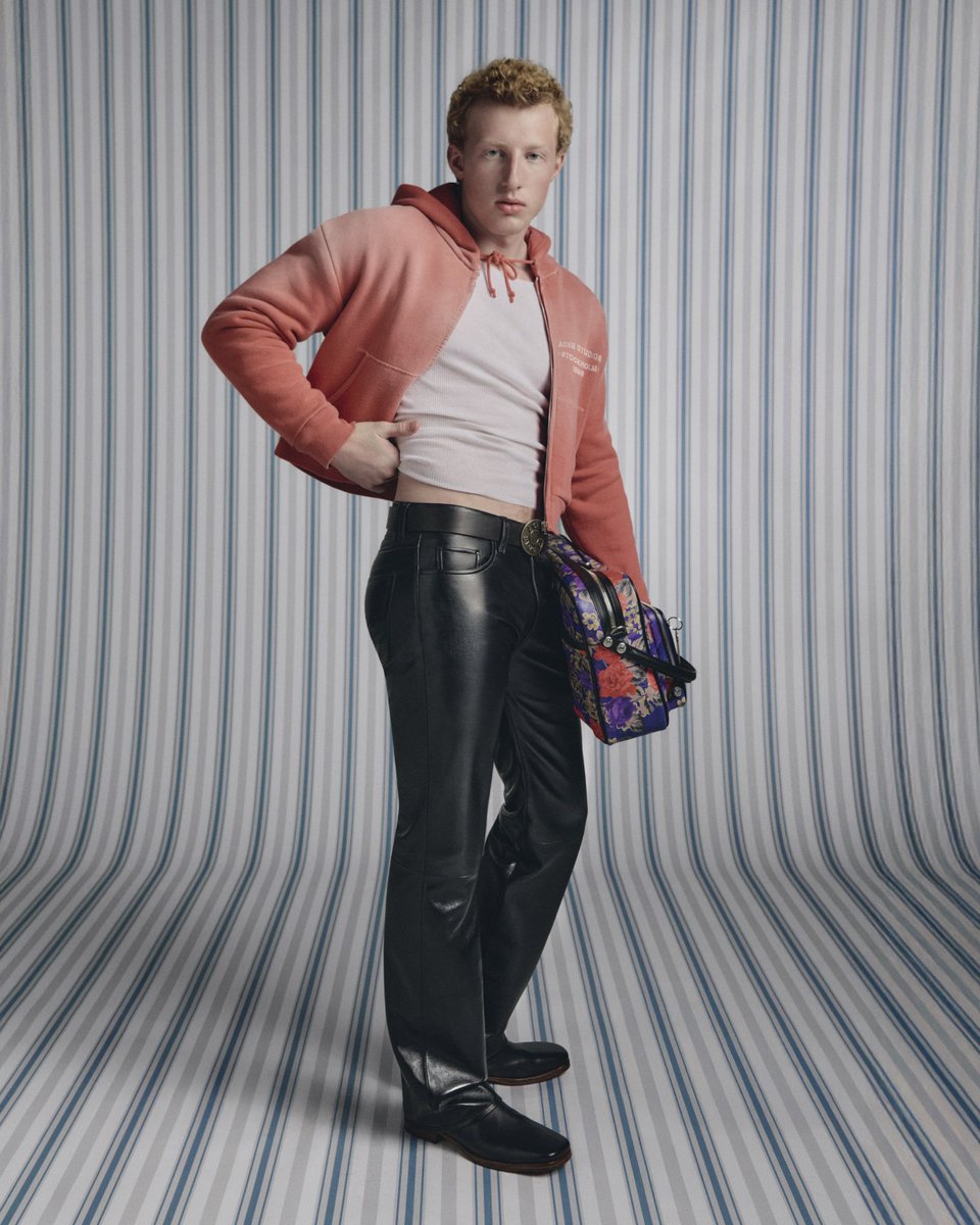 acnestudios's tweet image. Acne Studios SS26 menswear rewrites sportswear codes with precision.
Glossy textures, cropped hoodies, and sleek track silhouettes are paired with the Camero Camera bag in new iterations, alongside the debut of the Camero Hotel, a new shape designed for travel and adventure.