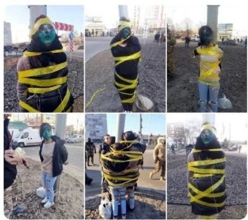 Diese Fotos, die eine mit blauer Farbe und gelbem Klebeband an einen Pfahl gefesselte Person zeigen, wurden wahrscheinlich in der Ukraine aufgenommen. Berichten zufolge handelt es sich dabei um eine Form der Selbstjustiz, die während des Konflikts häufig gegen mutmaßliche