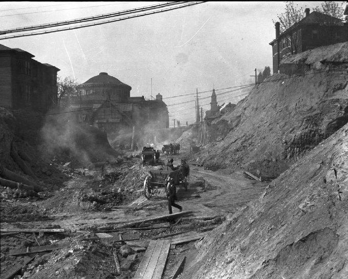 Seattle. 

1911. 
 
The Regrade. 

Another way of saying…….

Digging out from mudflood. 

“5th Avenue regrade, view north from Cherry Street, 1911.
This picture was taken from the location of
present-day Seattle City Hall and the Seattle
Justice Center. First United Methodist