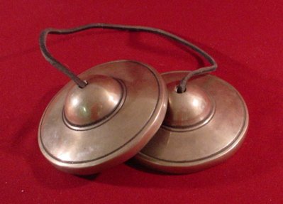 Hizi zinaitwa tingshas. Available on jumia and most online shops. 
They're simple and easy to carry and they have a very clear high pitched sound. Negative frequency cant stand this, especially if its ringing everywhere.