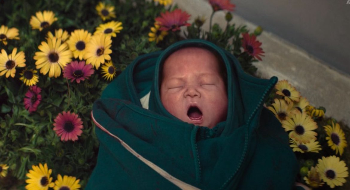 junhee dying on painted flowers meanwhile her baby lays on real colorful flowers