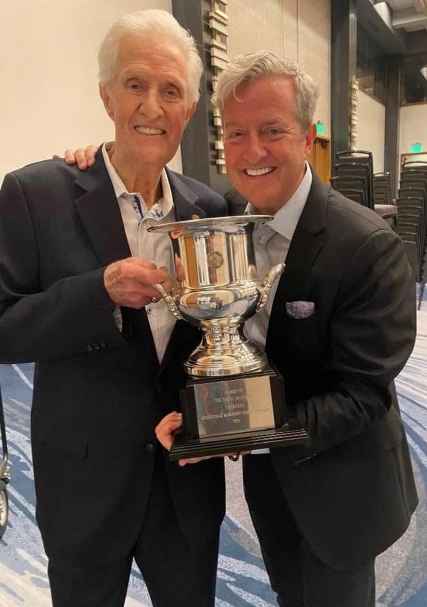 A Personal Message from Greg Clancy, Vocal Majority Musical Director:
Fifty years ago today, June 28th, 1975, I stood on stage with my dad and 90 other men as The Vocal Majority won its first Gold Medal. This is my dad and me with the trophy from 1975. We took this picture in