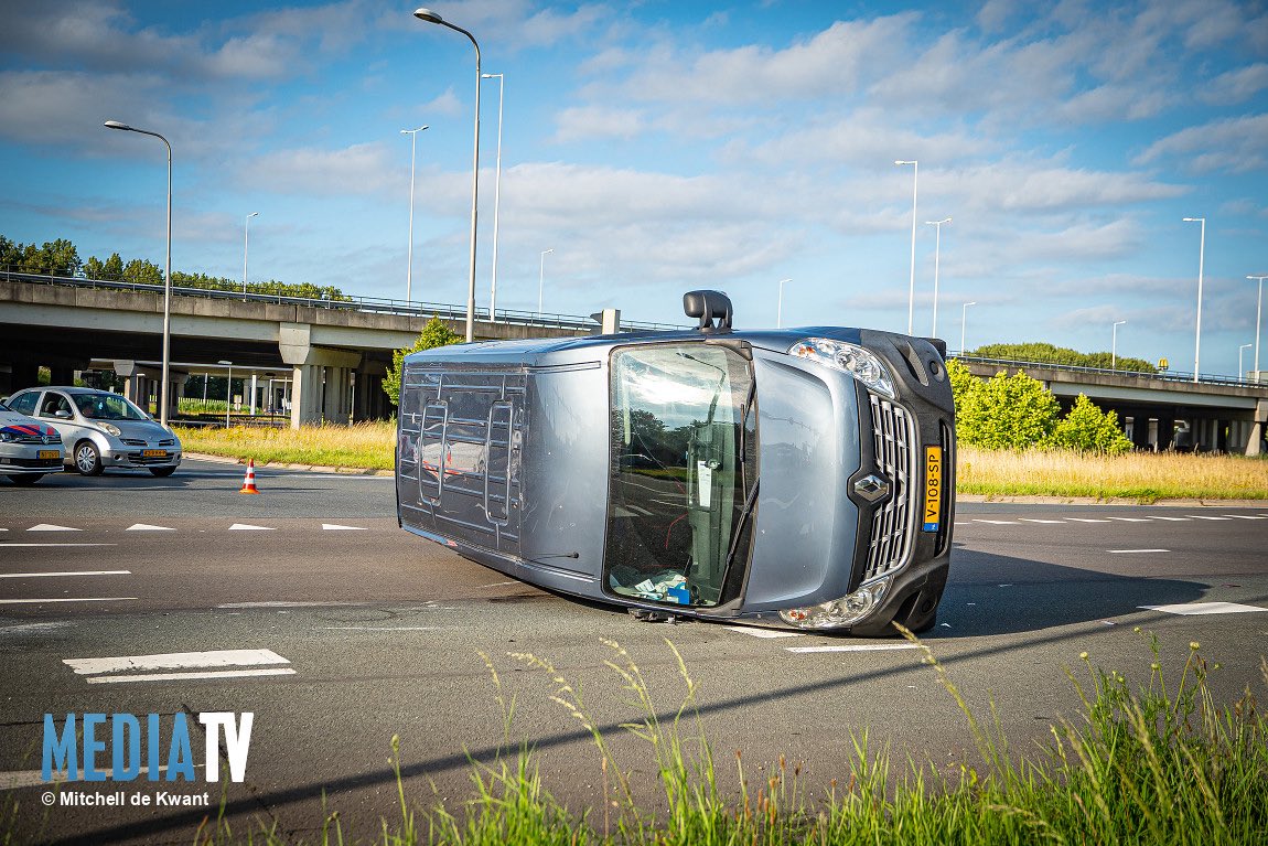 Bedrijfsbus op zijn kant na aanrijding met personenauto op Groene Kruisweg
