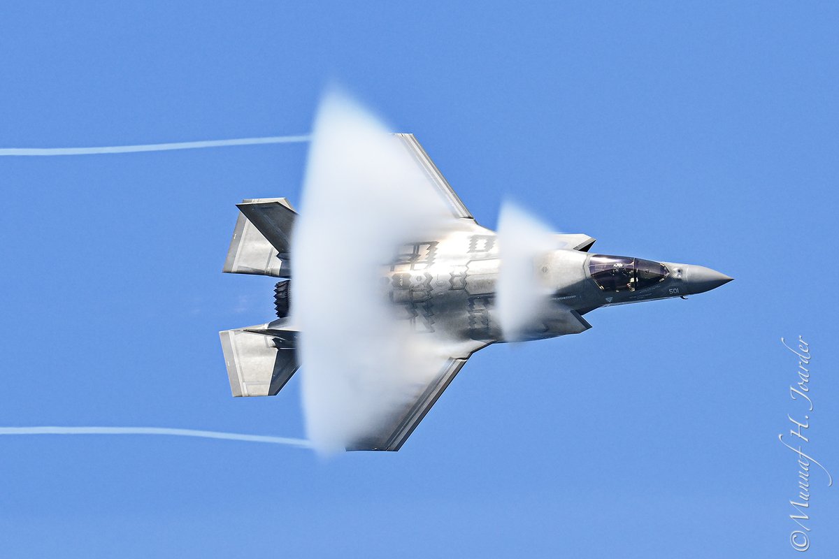 USMC F-35B with vapor cone during flight demonstration at Traverse City Air Show.  A vapor cone, also known as a Mach cone, is a visible cloud of condensed water vapor that can form around an aircraft traveling at transonic speeds (near the speed of sound).