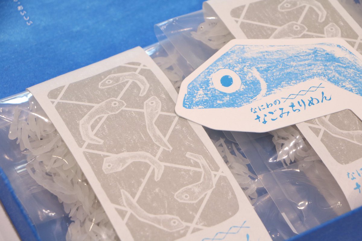 【PACKAGE VOICE展 作品紹介-6】
株式会社坂井印刷所
“なにわのなごみちりめん”

「まんだら」に、クレヨンで描いたイラストを水色、紺、グレーの特色でクレヨンの風合いが出るようデザインして印刷。紙表面のまばらな光沢を活かして大阪湾(魚庭=なにわ)の海面のきらめきを表現していただきました。