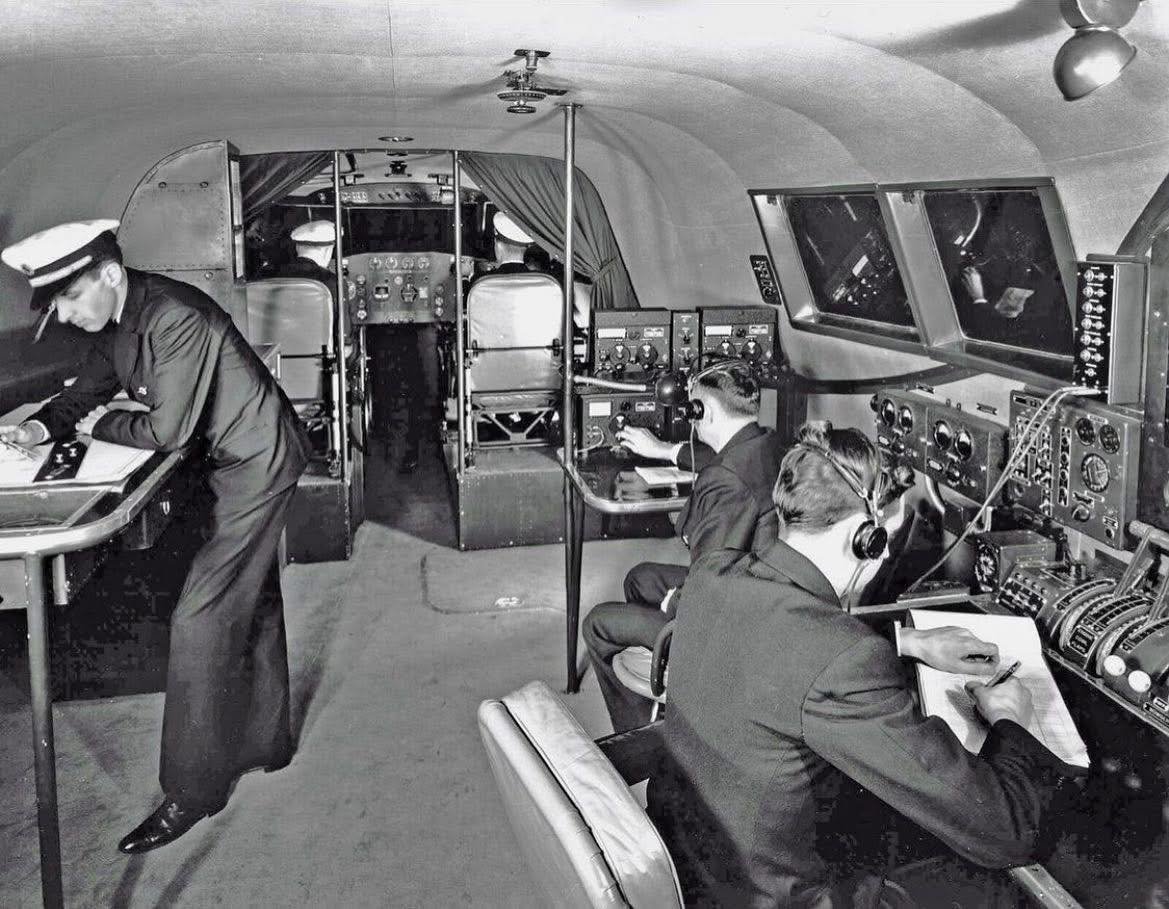 Boeing 314 Flight Deck. Between the Navigator and Radio operator there's a stack of equipment.