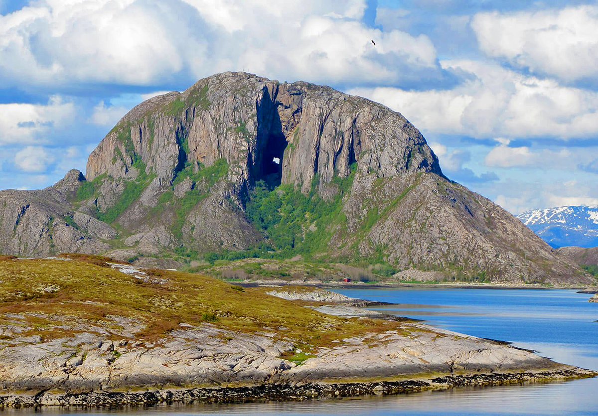 geologyBits's tweet photo. In Geology ✔️ Mineralogy - Botany
#Torghatten #NorwayGeology #IceAgeFormation #Nordland

🔁 Torghatten: Norway’s Mountain Pierced by Nature’s Force

▶️ Imagine walking through a 160-meter-long tunnel carved by ancient ice and waves, right through the heart of a granite mountain.

Torghatten, Norway’s iconic landmark, awaits your exploration.

Formation Story
Torghatten, located on the island of Torget in Nordland County, is famed for its natural tunnel, a geological marvel shaped during the Scandinavian Ice Age.

According to legend
the hole was created when the troll Hestmannen, enraged by unrequited love for the maiden Lekamøya, shot an arrow at her.

The Troll King of Sømna
threw his hat to block the arrow, and as the sun rose, all turned to stone, leaving the hat as Torghatten with its iconic hole.

Scientifically, the tunnel formed
over millennia as ice and water eroded softer rock layers, while the harder granite above resisted, creating a striking passage.

Geological Information  
Location: Torghatten is a granite dome on Torget Island, Brønnøy Municipality, along Norway’s Helgeland coast.
  
Rock Composition
Composed of Precambrian granitic gneiss, formed 1880–1750 million years ago, part of a small basement window surrounded by Caledonian rocks (542–416 Ma).
  
Tunnel Dimensions
160 meters long, 35 meters high, 15–20 meters wide, formed as a marine abrasion cave during the Ice Age.
  
Formation Process
During the late Weichselian glacial maximum (~20,000–22,000 years ago), the area was under ~1,000 meters of ice.

As glaciers
retreated ~12,000 years ago, sea levels were ~100 meters higher, eroding softer rock via wave action and subglacial meltwater.

The tunnel is a polygenetic landform
shaped by glacial meltwater drainage, plastically sliding ice, and marine abrasion over at least two glacial cycles.
  
Geological Features
The site displays p-forms (plastically molded forms from ice flow), beach ridges from higher sea levels, and potholes formed by rotating water and gravel under glaciers.
  
Significance
Part of the Trollfjell Geopark, Torghatten exemplifies quaternary landscape evolution, showcasing glacio-isostatic changes and frost-action processes.

▶️ Interesting Fact
The tunnel’s walls bear the carved signatures of Norwegian kings, Oscar II, Olav V, and Harald V, etched during royal visits, a testament to Torghatten’s enduring cultural and geological significance.

Have you hiked through Torghatten’s tunnel or explored other geological wonders?

🔁 Like & Share your experiences or which Norwegian landmark you’d visit next in the comments!   

🎞️ One of the most unique views in the world
https://t.co/FsQIDwbQWk