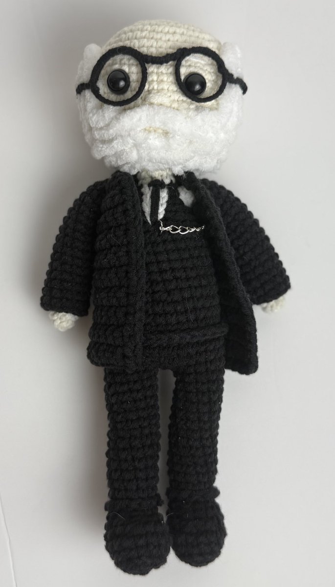 🧠🧶 “في كل عقدة غرزة… وفي كل غرزة فكرة.”
هكذا يعود سيغموند فرويد، مؤسس التحليل النفسي، لكن هذه المرة من خيط وإبرة، ضمن عمل فني يجمع بين الرمز والدقة.

دمية كروشيه لسيغموند فرويد – من ستوديو فاڤ.
ببدلته الكلاسيكية، نظارته المستديرة، ولحيته البيضاء، يظهر فرويد في صورة ناعمة