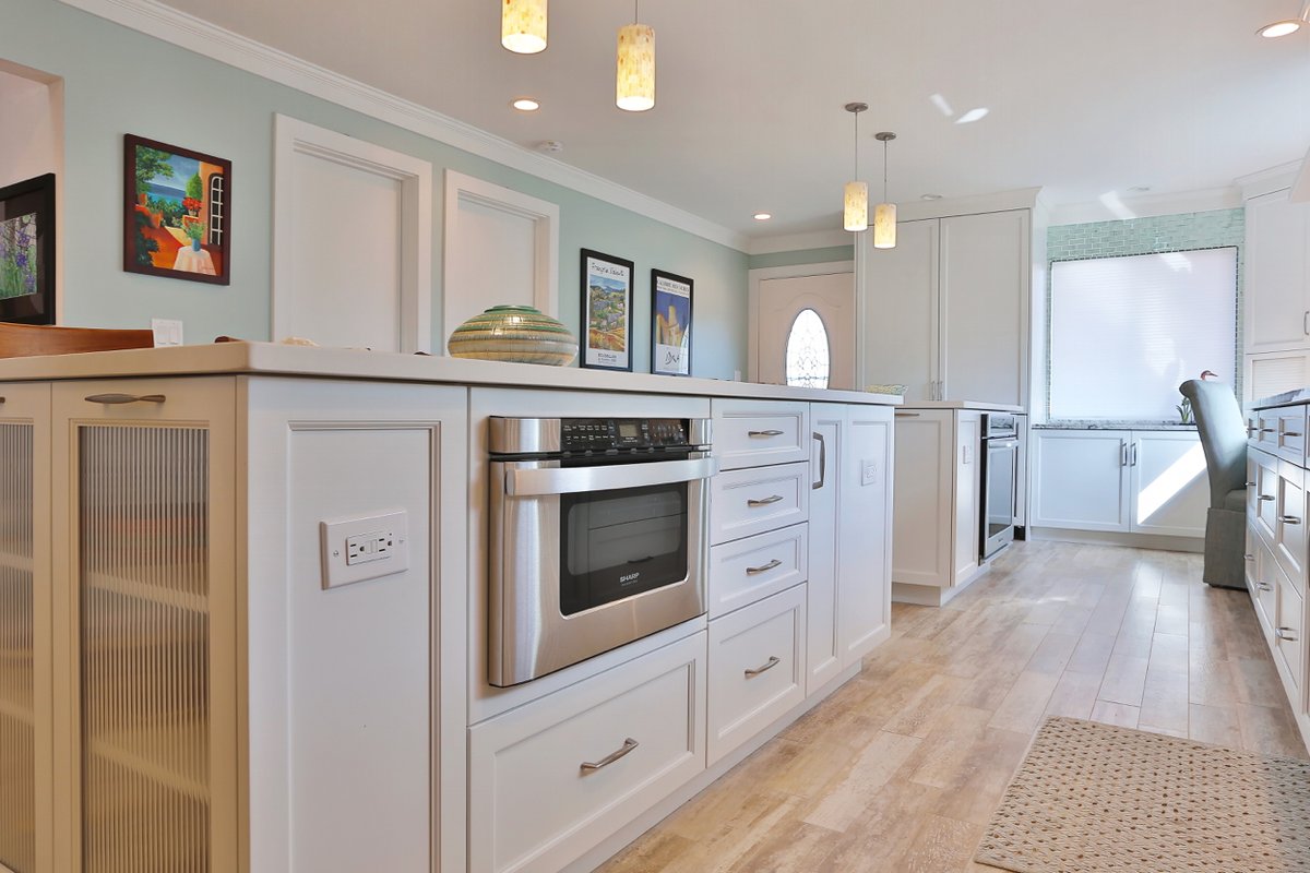 Twin islands take center stage in this timeless kitchen! Thomas R. Kelly of TRK Design Company designed this Venice, FL kitchen with a matching hood to bring a clean and cohesive look to the space.

#KounrtryKraft #CustomCabinets #CustomCabinetry #Kitchen #WhiteKitchen