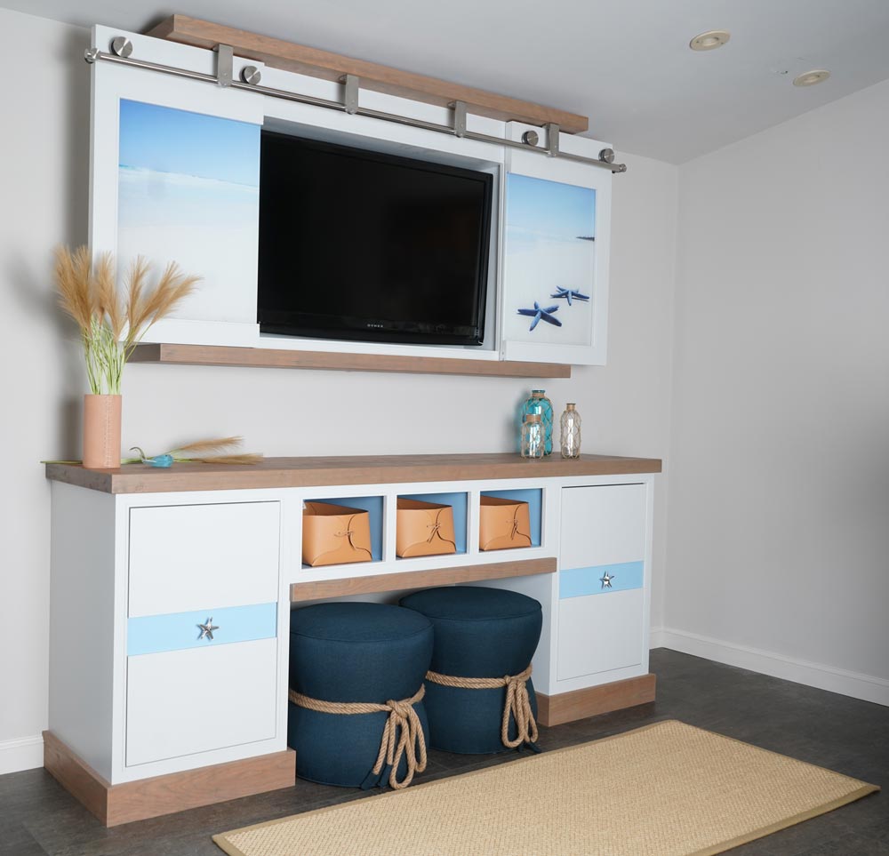 This entertainment center captures serene beach vibes with a custom printed beach scene on the glass doors by Imagio Glass. Cabinets finished in Benjamin Moore Graytint with a Sherwin Williams Porch Ceiling inlay and starfish hardware keep the design cohesive.
#KountryKraft