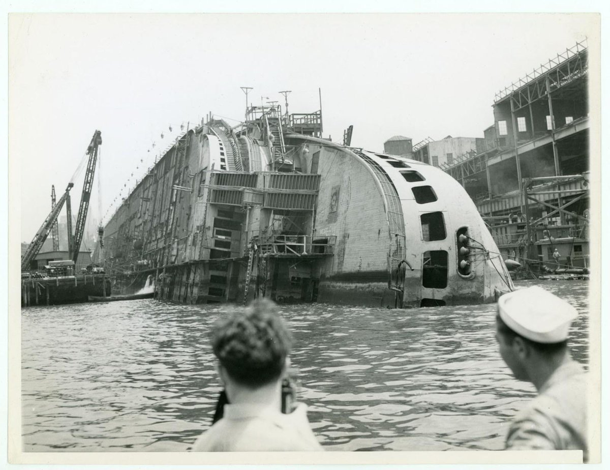 #OnThisDay in 1943 this photograph was taken depicting the tipped over #OceanLiner SS Normandie undergoing salvage. The ship was being retrofitted for use in #WWII when a fire broke out. See Normandie’s wheel, burn marks and all, at the Museum! bit.ly/x-maritime-city