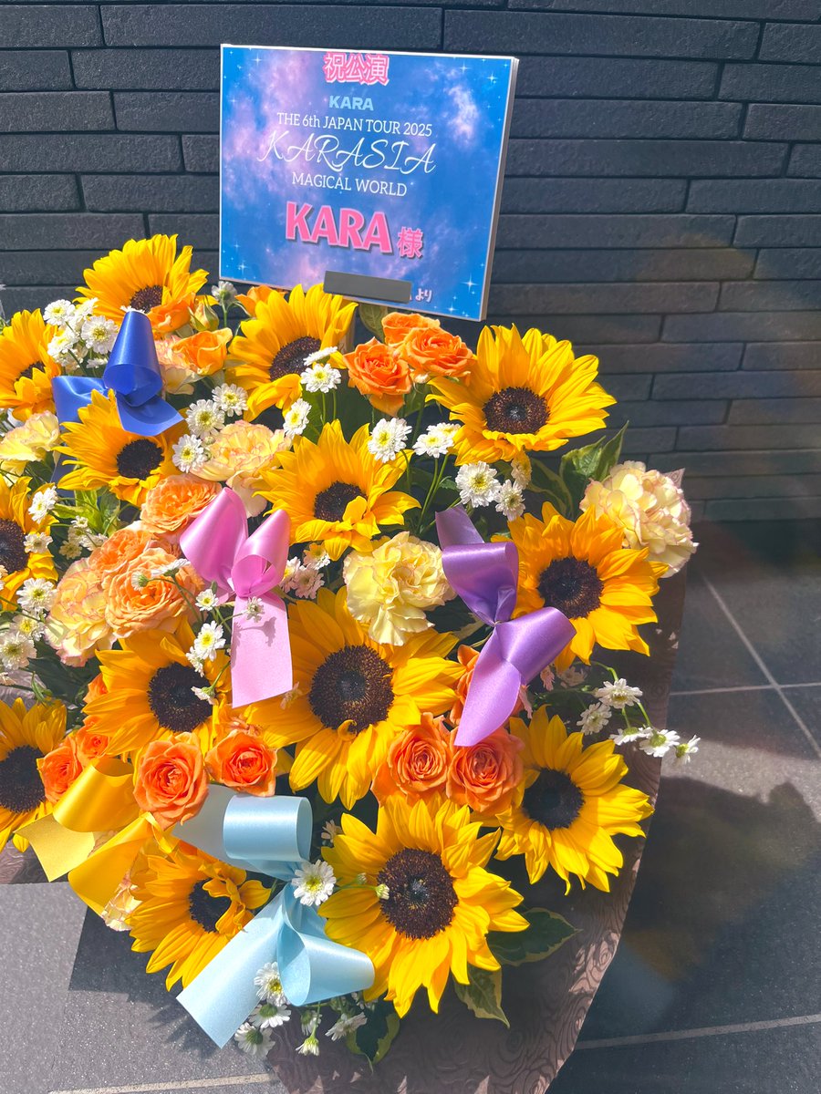 hana__nadeshiko's tweet photo. 2025.7.5~6（2Days）🗓️
横浜　ぴあアリーナMMにて📍

【KARA THE 6th JAPAN TOUR 2025　“KARASIA : MAGICAL WORLD”】

KARA様へ
@gyuri88  @fateflysy 
@_sweethara  @_911007 
@kkangjji_0 @youngjijjang2ya

ひまわりたっぷり🌻
黄色、オレンジ系のビタミンカラーでお作りした楽屋花をお届け致しました🧡
メンバーカラー６色のリボン付きです🎀

RT拡散andフォローお願い致します。
お問合せ、ご注文はDMよりお気軽にしてください✉️

#フラスタ #フラワースタンド #バルーンスタンド #推し活 #推し色 #俳優 #声優 #アイドル #楽屋花 #アレンジメント #卓上花 #祝花  #オリジナルフラスタ #ひまわりアレンジメント #KARA #카라
#KAMILIA #KARASIA #박규리 #GYURI #ギュリ #한승연 #SEUNGYEON #スンヨン #구하라 #HARA #ハラ　#정니콜　#NICOLE #ニコル #강지영 #JIYOUNG #ジヨン #知英 #허영지 #YOUNGJI #ヨンジ