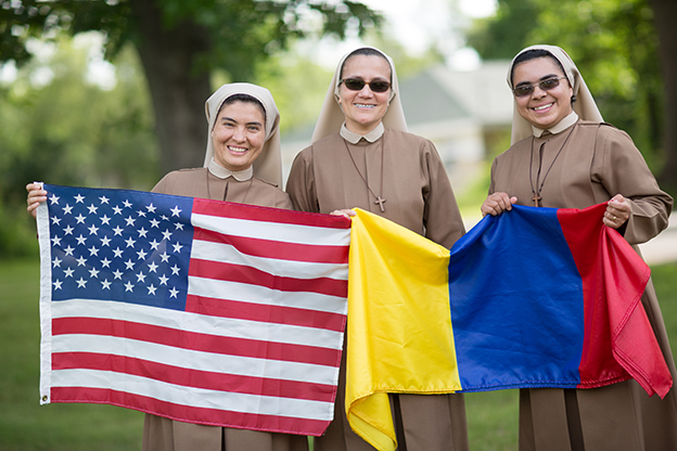 NunsHolding's tweet image. Three Missionary Servants of the Divine Spirit (MSDE) in Kalamazoo, Michigan holding an unfolded United States of America flag and a partially-folded Columbia flag. Photo from @CathExtension at catholicextension.org/stories/destin….