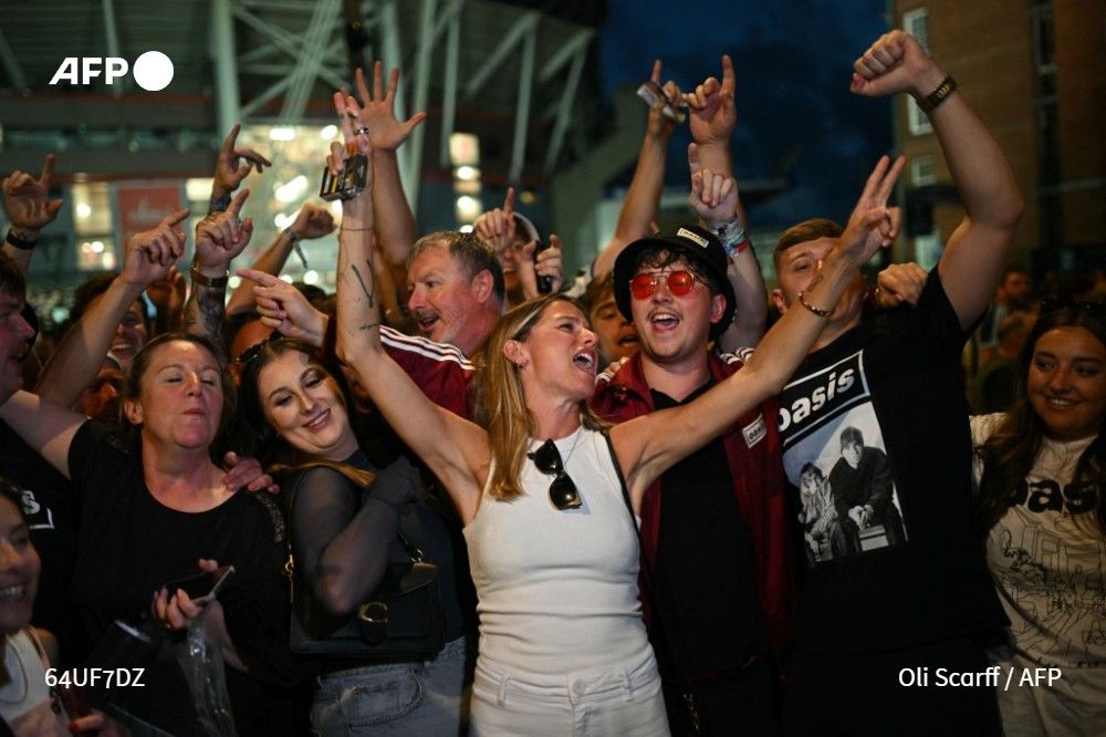 Fans of British rock band Oasis sing outside the Principality Stadium in Cardiff on July 4, 2025, after attending the opening concert of the band's highly anticipated reunion tour
