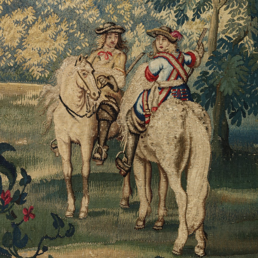V_and_A's tweet image. This tapestry replica of ‘July’ from Charles Le Brun’s 1668 series shows Louis XIV hunting with courtiers amid symbols of power & wealth. Made by Jean de la Croix’s workshop, it adapts royal designs for elite clients, keeping the grandeur without gold threads.