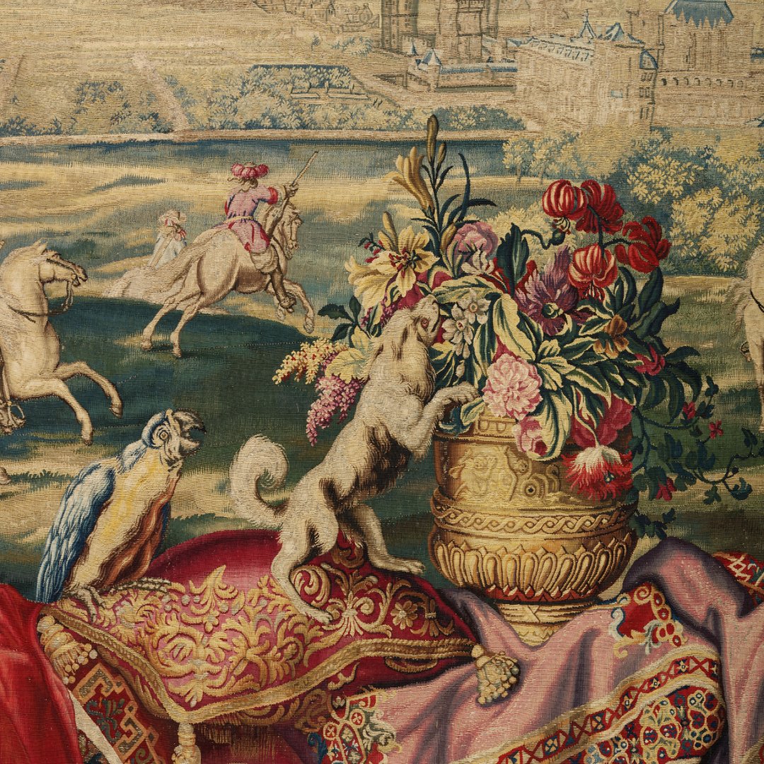 V_and_A's tweet image. This tapestry replica of ‘July’ from Charles Le Brun’s 1668 series shows Louis XIV hunting with courtiers amid symbols of power & wealth. Made by Jean de la Croix’s workshop, it adapts royal designs for elite clients, keeping the grandeur without gold threads.