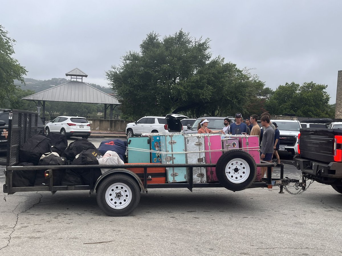 EvaRuth's tweet image. As choppers search from above, campers from an all-girls camp reunite with cheering parents in downtown Kerrville. Counselors from nearby camps help load and unload trunks.