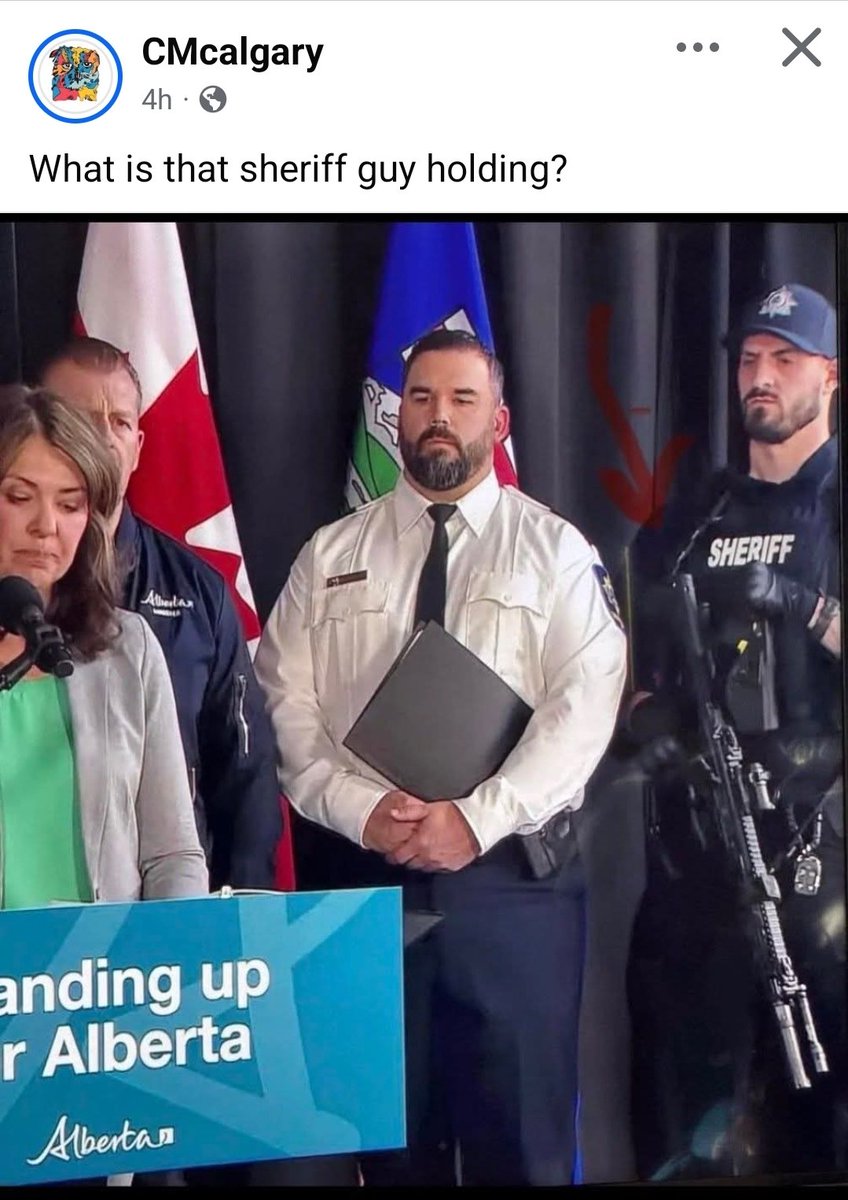 What is this all about?? A 'Sheriff' with an assault rifle at the presser??