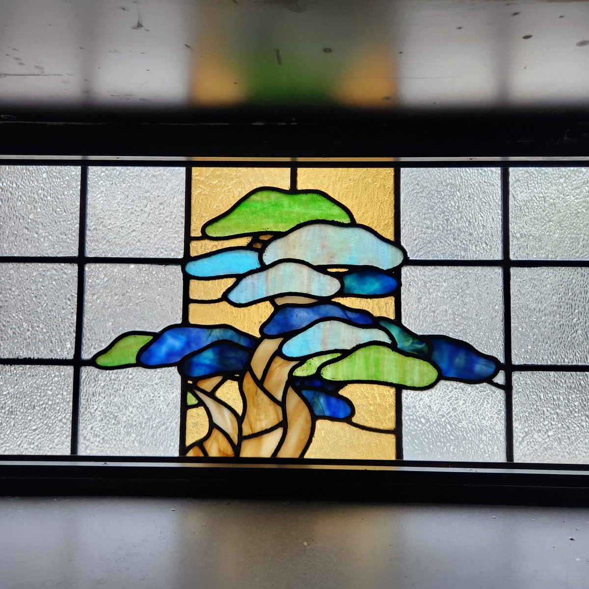 能楽書林ビルにある鏡板の松をモチーフにしたステンドグラスですが、1990年竣工の現在のビルの前にも掲げられていたそうです。新しく作り直したため、建て替え前のステンドグラスは残念ながら残っていません。
室内から見るととてもキレイです。