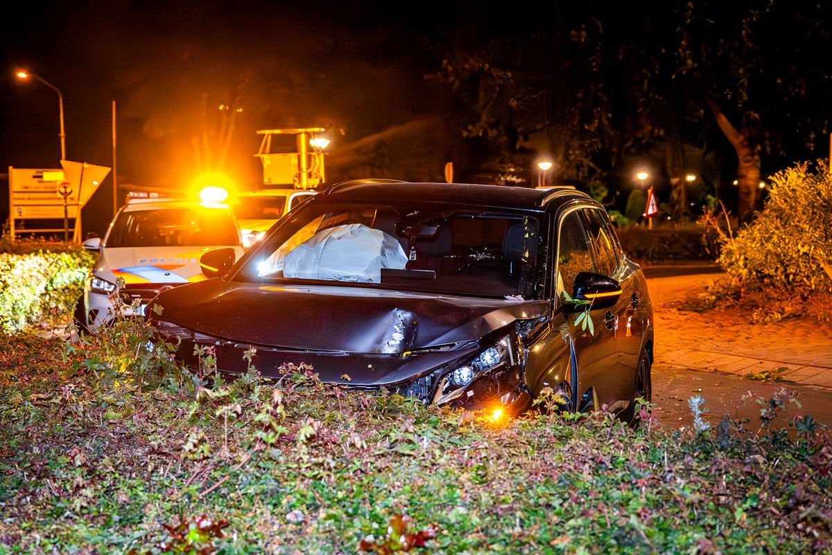 Auto ramt heg op rotonde, bestuurder gewond naar ziekenhuis