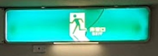 「非常口」のピクトグラムが施行されたのは1982年。ニュージャパンの火災も影響し、1年半で70%以上がピクトグラムに交換されたらしい（wikiより）ので、ピクト化は82～84年頃に生じた急激な風景の変化といえそう。  
現在も残る文字だけ非常口は、その時代をすり抜けた、かなり貴重な存在だろう。