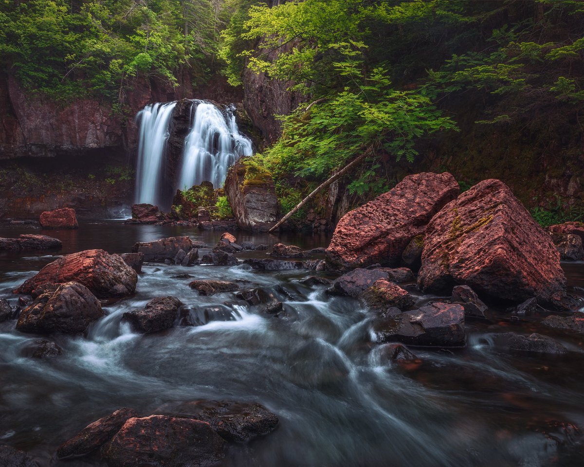 From the moment I came upon this scene I loved how the rich red of those rocks stands out against all that lush green, and how the river’s gentle flow guides your eye right into the heart of the falls. Framed this to capture the contrast and movement. From a Landscape