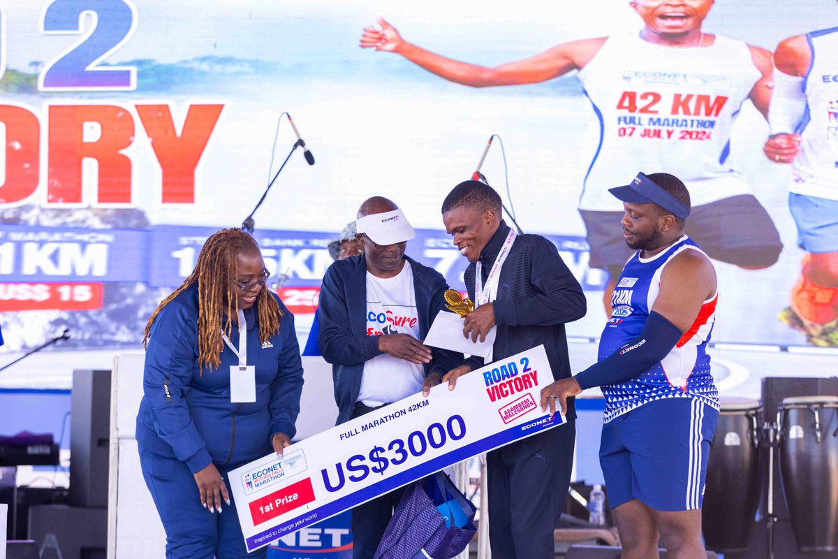 Econet General Manager – Marketing, Mrs Tariro Muchena (left), and Finance Director, Mr Chengeto Moyo, present the winner’s prize to men’s marathon champion, Blessing Waison, at the 2025 Econet Victoria Falls Marathon, while Victoria Falls Mayor, Mr Prince Moyo, looks on.