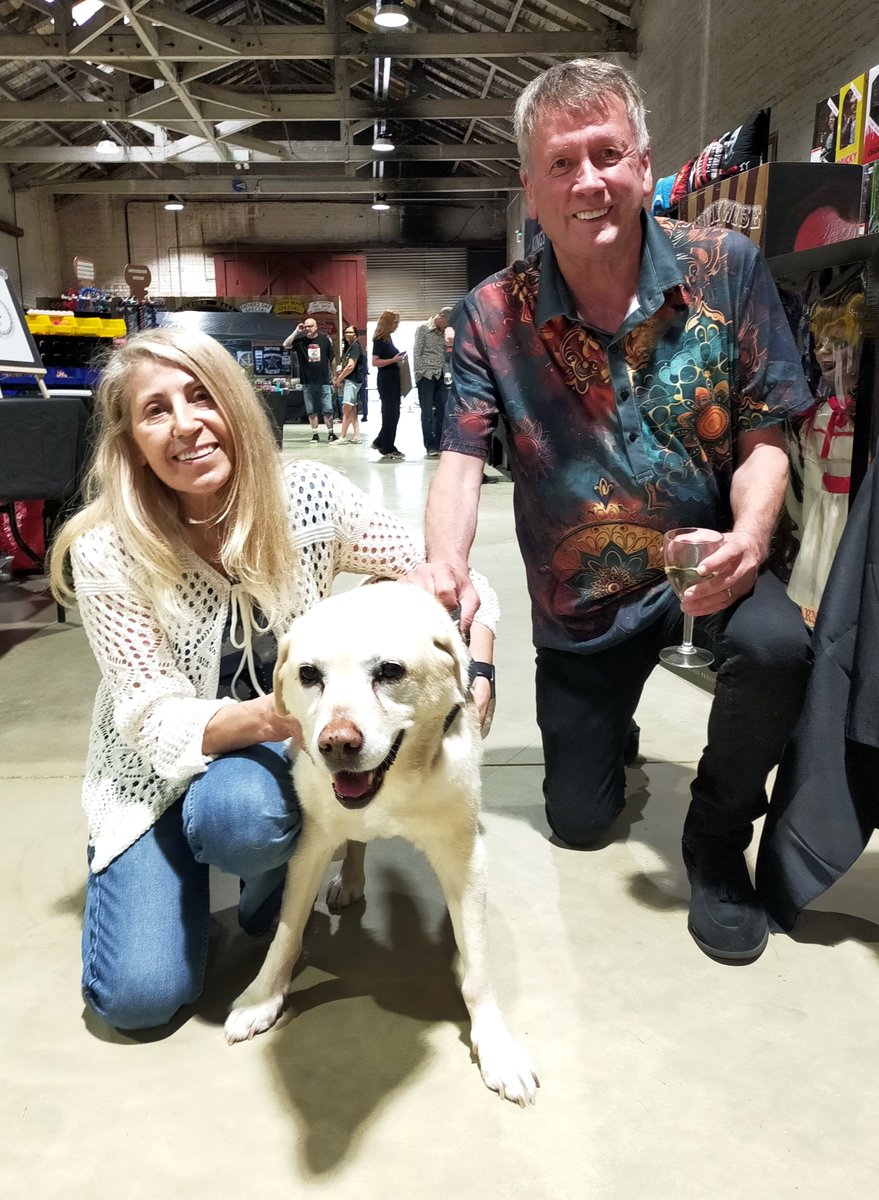 Tuftenstein's tweet photo. DarkSide supremos Allan &amp; Yannie were on hand yesterday.  They also had their lovely doggo, Holly behind the stand.  I asked if I could sneak a pic for @lordRsBiscuits and they very kindly posed for this lovely photo. The nicest people in horror? I reckon so...💀🐶 #ShedOfHell https://t.co/NGwFDSZqS3