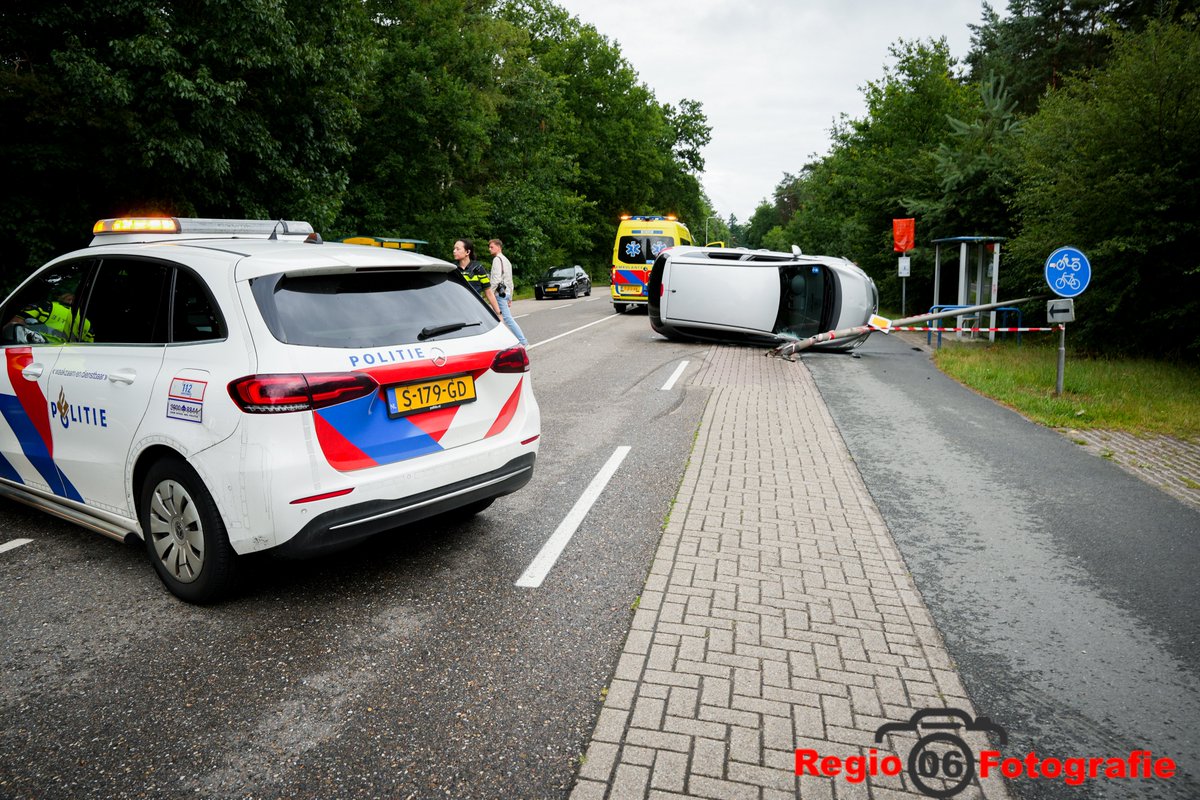 Auto op zijn kant na ongeval in Beekbergen