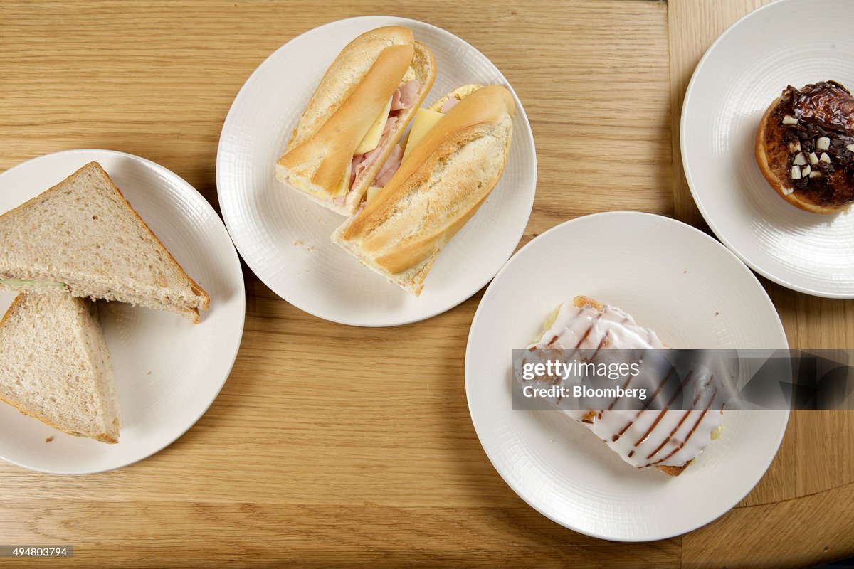 Food products from Greggs Plc's, left to right, Tuna Mayonnaise and Cucumber sandwich, Ham and Cheese baguette, Apple Danish and a Triple Chocolate Doughnut sit on a counter during a Greggs Plc taste test in London, U.K., (2015)