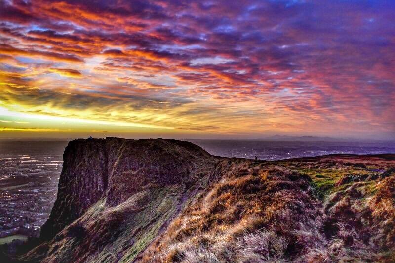 Cavehill~ Beann Mhadagáin~ ‘Madagán’s peak’, Madagán being the king of Ulster who died in 856AD. 

There are in fact three caves on the face of the cliff which stands in the townland of BALLYAGHAGAN. 

It is also referred to as Binn Uamha [bin oova] ‘peak cliff of the cave’.