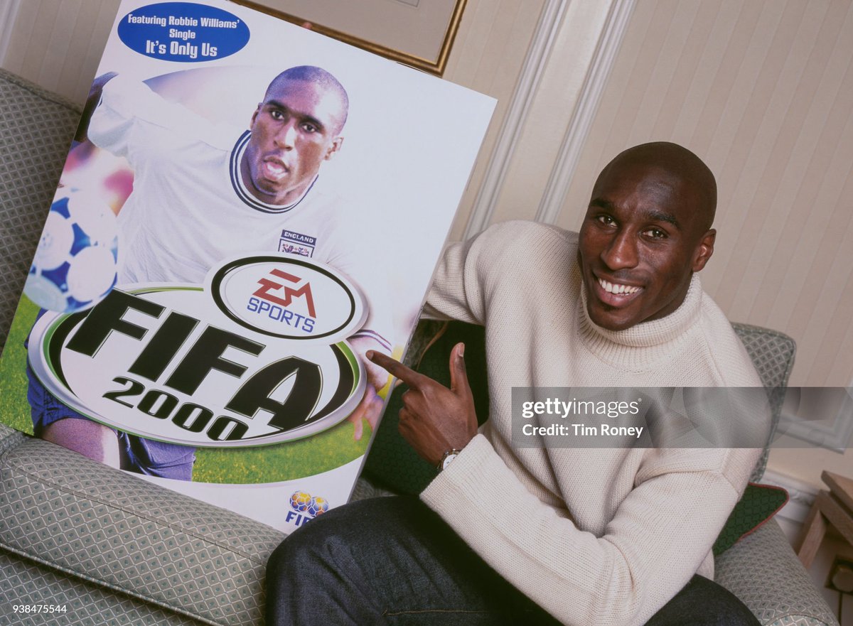 English soccer player Sol Campbell with a hardcover of video game 'FIFA 2000' international edition cover, which featured him (2000)
