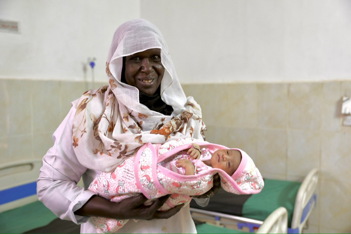 _UnfpaSudan's tweet image. In Khartoum, Midwife Makarem cradles baby Mohamed. His mother, displaced for two years, has finally returned home to give birth. Investing in reproductive health services makes moments like this possible, helping more women come home and receive the care they need. #ForSudan