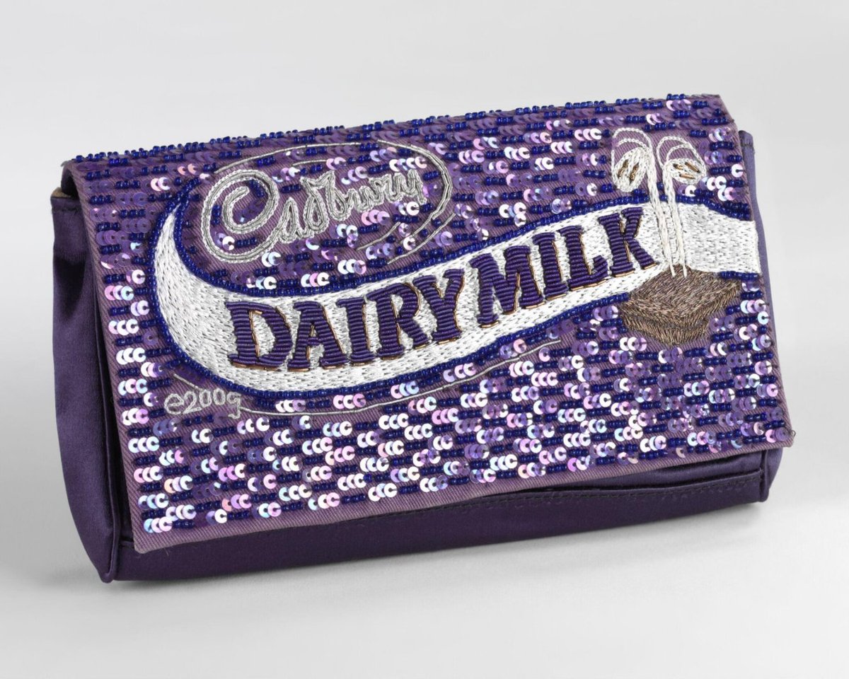 V_and_A's tweet image. What’s the ultimate sweet treat? 🍫
Anya Hindmarch’s clutch reimagines the iconic Cadbury Dairy Milk bar with purple sequins, embroidery & wit, turning chocolate into couture. 💜