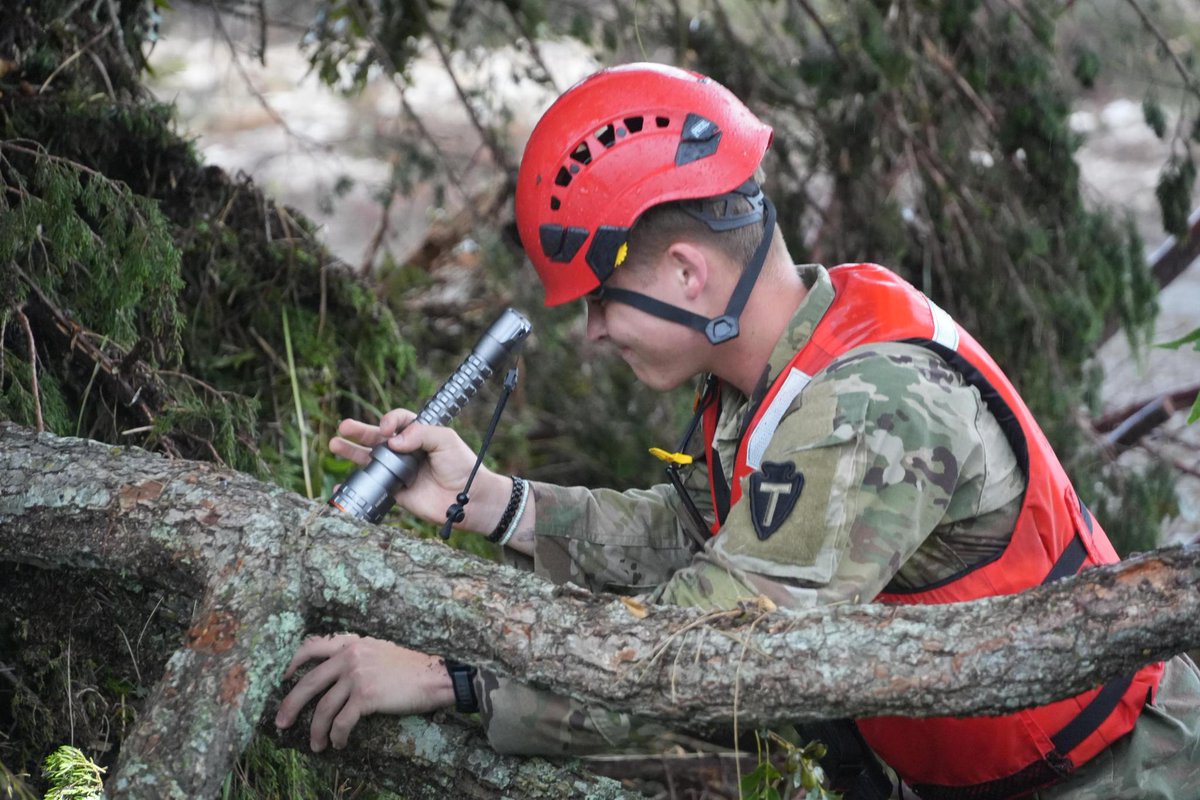 TXMilitary's tweet image. Texas National Guard service members assigned to Task Force Storm work in teams along the Guadalupe River bank conducting search and rescue operations and removing debris near Camp Mystic in Kerr County, Texas.