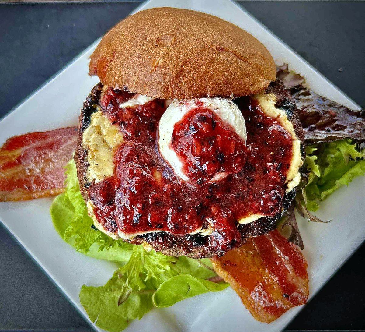 Crow's Nest WEEKLY SPECIAL • 🍔 The Duchess 🍁:  brown sugar-rubbed, maple syrup-glazed 8oz burger, bacon, spring mix, melted cream cheese, and a triple-berry chutney on toasted brioche bun - $17, comes with a side. Available July 7-11