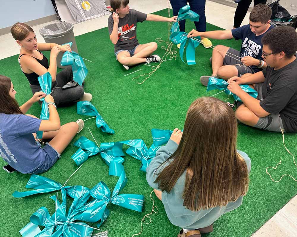 Many volunteers contact their local scouts, church and youth groups to assist in making bows and putting up our ribbons. Utilizing young people has many benefits as they learn about Ovarian Cancer and that this campaign SAVES WOMEN’S LIVES. Register at turnthetownsteal.org.