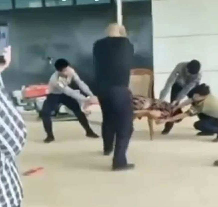 A shocking viral video has surfaced, capturing the factory owner in Hlaingtharyar township, Yangon—a man reportedly of Chinese descent—brutally beating a female employee with a wooden stick, while three police officers restrain her in Myanmar. 

Despite attempts to justify this