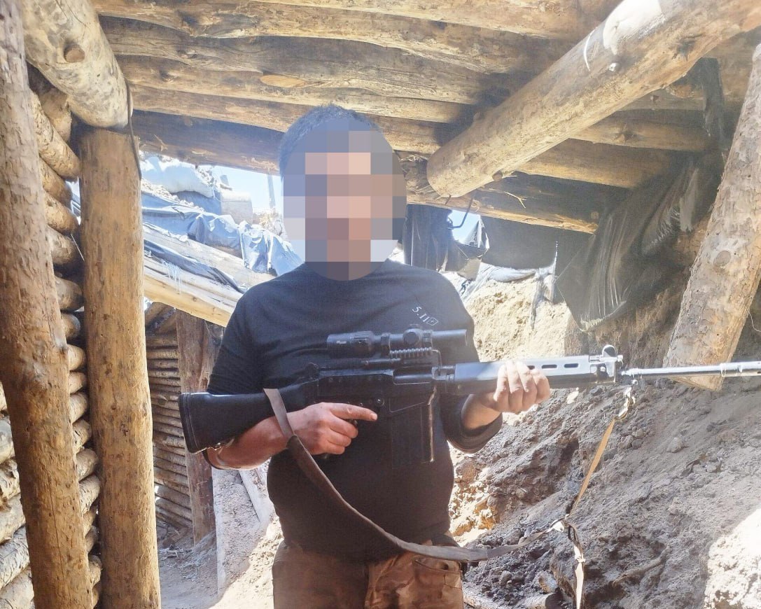 A ruSSian soldier with a captured FN FAL automatic rifle fitted with a Sig Sauer Tango optic.