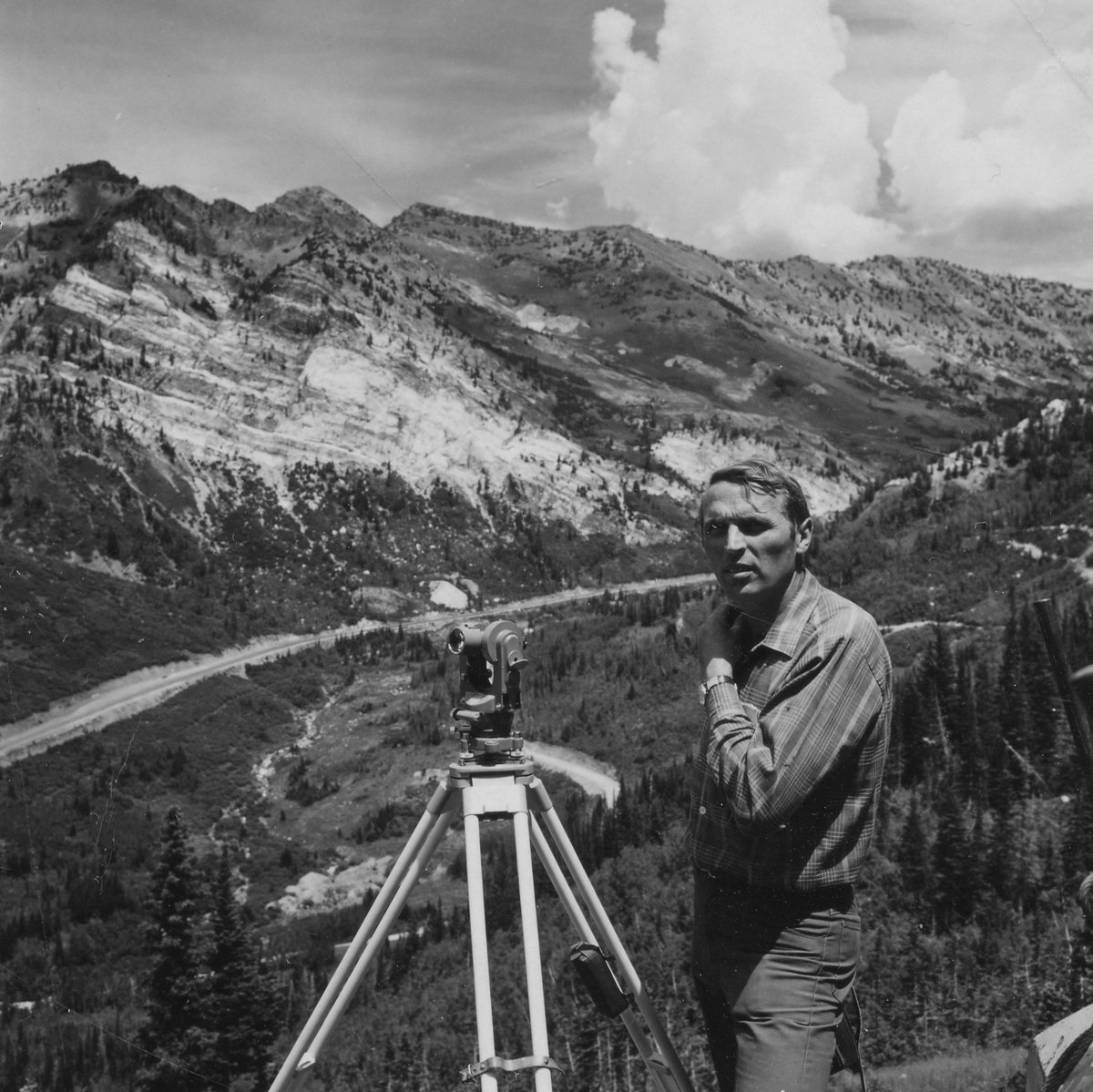 Snowbird's tweet image. Hans Burkhart sights the Aerial Tram tower footings with the Hellgate Cliffs rising behind him. Instrumental in constructing the Tram and 3 original ski lifts (Gad 1, Gad 2 and Wilbere), Hans laid the groundwork for Snowbird’s opening less than 2 years later. Summer 1970.