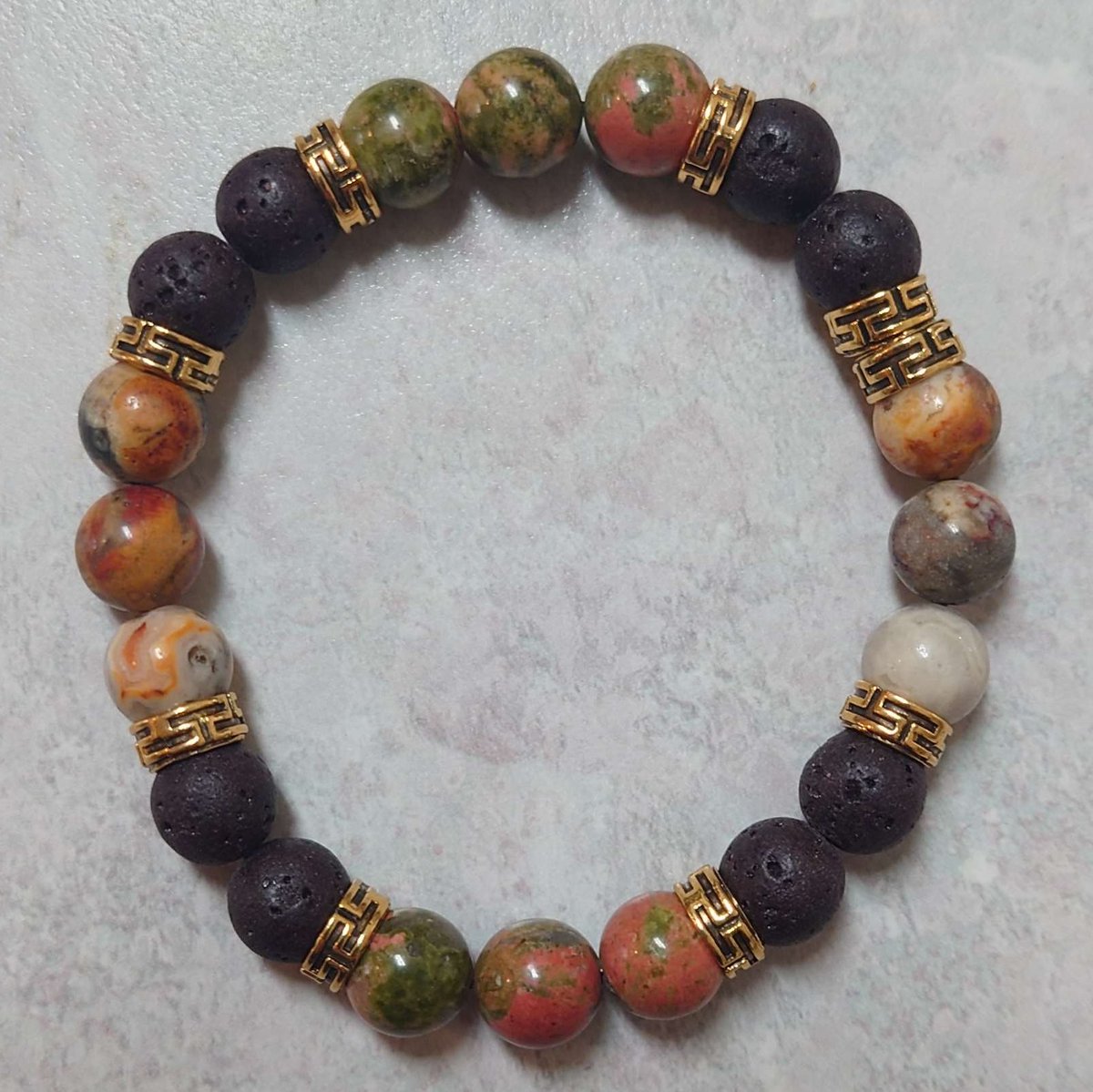 I finally made a gift bracelet for my mother. The stones are lava rock, crazy lace agate, and unakite. It came out rather nice, and while I don't want to brag or anything, I do think I'm starting to get the hang of these.

I'm probably going to make some bracelets for my various