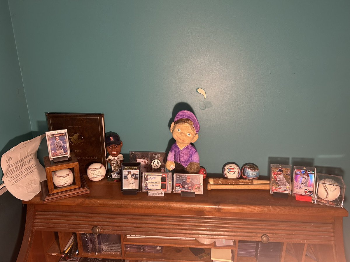 keeper27storm's tweet image. Baseball display on my card desk😍
-Zac Gallen corner
-1969 Red Sox Photo book from my Memé
-Couple Big Papi items
-Creepy statue (painted by me)
-Acuna red ink, Devers/Jram dual auto, Soto RC SP
-A few cool balls
-Devers corner (w/ custom mini bat)
-Mini Louisville Slugger