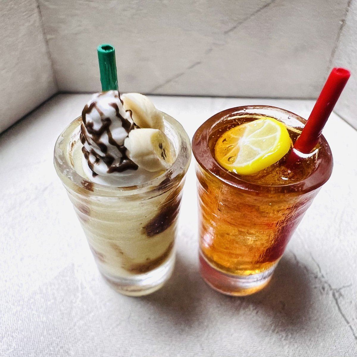 みてください！
このレモンティーとチョコバナナシェイクを！！😳
めちゃくちゃ小さいミニチュアなんですけど、レモンティーの色といい、ストローの屈折といい、バナナシェイクのリアルさといい…✨✨
Atelier Kさん<a href="/AtelierK14/">Atelier K【デザフェス7/6のみ N-64】</a> の作品です。
素敵…💖

拡大するとお腹減ります😋

#デザフェス戦利品