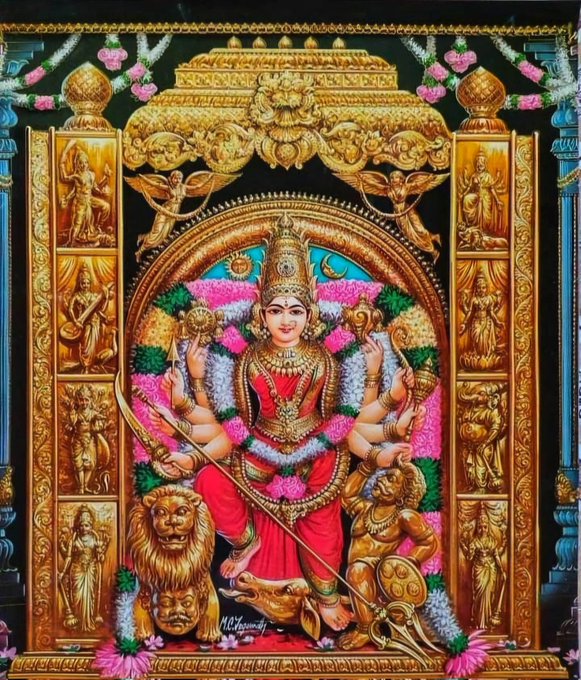 The image depicts a detailed and ornate representation of Kanakadurga Devi, a Hindu goddess, located in Vijayawada. The goddess is shown with multiple arms, each holding different symbolic items, and she is adorned with traditional jewelry and garments. She stands on a lion, which is a common depiction of fierce goddesses in Hindu iconography. The backdrop is richly decorated with golden motifs and smaller carvings of other deities, enhancing the divine and sacred atmosphere of the image. The post text confirms the identity of the deity and the location, providing context to the religious significance of the image.